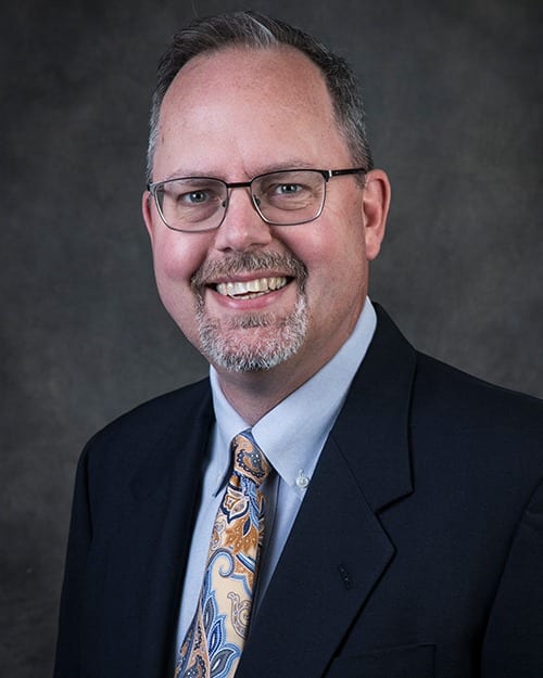 headshot of dr. poupard wearing a pink tie